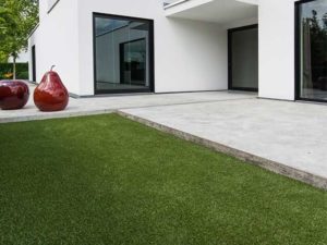 White patio with back of house and artificial grass