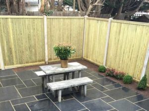 City garden with slate paving and timber fence