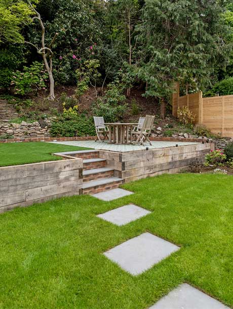 tiered-garden-with-grass-stepping-stones-table-and-chairs