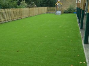 Artificial grass surrounded by wooden fence